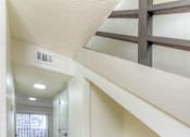 Thumbnail 7 of 24 - A long hallway with a bench and a window.at The Garden District Apartments, Germantown Tennessee  