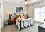 Thumbnail 5 of 25 - Secondary bedroom with ceiling fan and large window at Grand Island Apartments in Memphis TN 38103