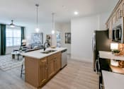 Thumbnail 5 of 28 - A modern kitchen with wooden cabinets and a large island. at Grays Creek Apartments, Cordova, TN, 38018
