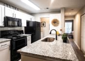 Thumbnail 1 of 36 - Modern Kitchen with Granite Countertops and Black Appliances  at Grove Point, Norcross, GA, 30093