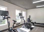 Thumbnail 24 of 37 - A room with exercise equipment and a TV at Harbor Side at Conwood Flats Apartments in Uptown Memphis, TN