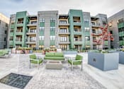 Thumbnail 10 of 37 - A courtyard with a bench and a tree in front of apartment buildings at Harbor Side at Conwood Flats Apartments, Memphis, TN, 38107