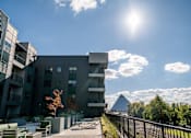 Thumbnail 17 of 37 - A sunny day at a modern apartment complex with a view of a pyramid-like structure in the distance at Harbor Side at Conwood Flats Apartments in Uptown Memphis, TN