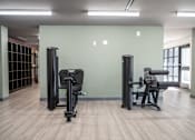 Thumbnail 25 of 37 - A gym with two exercise machines and a window at Harbor Side at Conwood Flats Apartments, Memphis