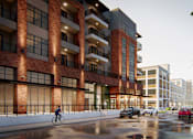 Thumbnail 1 of 2 - a rendering of a tall brick building with a street with cars and a person riding