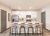 Thumbnail 1 of 18 - Modern kitchen with island bar at The Harrison in Sarasota, FL 34243