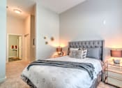 Thumbnail 3 of 14 - A bedroom with a large bed and a nightstand with a lamp at Highland Row Apartments, Memphis, TN,  38111