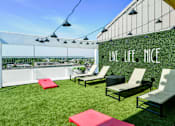 Thumbnail 3 of 38 - A patio with chairs and a wall that says "Live Life Nice".