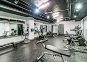 Thumbnail 32 of 38 - A gym with a variety of equipment including treadmills, weights, and exercise machines.