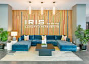 Thumbnail 1 of 38 - A living room with a blue couch and a sign that says "IRIS LUXURY APARTMENTS".