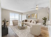 Thumbnail 19 of 38 - A living room with a white sofa, a glass coffee table, and a TV.at Iris Luxury Apartments, Memphis, TN  