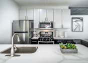 Thumbnail 7 of 38 - A modern kitchen with a stainless steel refrigerator, microwave, and oven.at Iris Luxury Apartments, Memphis, 38105  