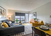 Thumbnail 9 of 38 - A living room with a grey couch, yellow chairs, and a dining table.at Iris Luxury Apartments, Tennessee, 38105