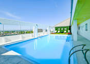 Thumbnail 2 of 38 - A large outdoor swimming pool with a white fence around it.