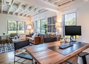 Thumbnail 12 of 28 - A modern home office with a wooden desk and black chairs at Kiwi Goji Apartments, Tennessee, 38111