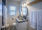 Thumbnail 27 of 28 - a bathroom with circle mirror at Kiwi Goji Apartments, TN, 38111