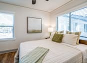 Thumbnail 22 of 28 - a bed with a blanket and accent pillow at Kiwi Goji Apartments, Tennessee