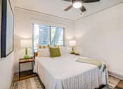 Thumbnail 23 of 28 - a bed with a white comforter and green accent pillow at Kiwi Goji Apartments, Memphis