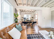 Thumbnail 7 of 28 - Living Room with a leather couch and desk in distance at Kiwi Goji Apartments, Memphis, TN,  38111