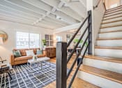 Thumbnail 16 of 28 - a view of a living room behind a staircase at Kiwi Goji Apartments, Memphis, Tennessee