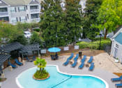 Thumbnail 13 of 28 - an aerial view of a resort style pool with lounge chairs and umbrellas