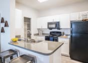 Thumbnail 1 of 24 - a kitchen with white cabinets and black appliances at Lincoln at Wolfchase, Cordova