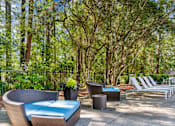Thumbnail 20 of 29 - A patio with a blue cushioned chair and a white chair. at Manchester at Mansell, Georgia 