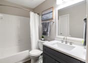 Thumbnail 9 of 29 - A white bathroom with a toilet, sink, and bathtub. at Manchester at Mansell, Georgia 