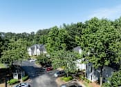 Thumbnail 27 of 29 - A tree-filled street with cars and houses. at Manchester at Mansell, Roswell, GA 30076 
