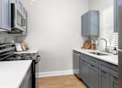 Thumbnail 12 of 29 - A kitchen with a stove top oven and a refrigerator. at Manchester at Mansell, Roswell, GA
