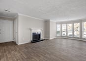 Thumbnail 4 of 29 - A living room with a fireplace and wood flooring. at Manchester at Mansell, Roswell, GA