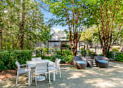 Thumbnail 19 of 29 - A patio with a table and chairs surrounded by trees. at Manchester at Mansell, Georgia 