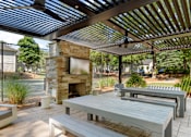 Thumbnail 23 of 29 - A patio with a fireplace and seating area. at Manchester at Mansell, Roswell, GA