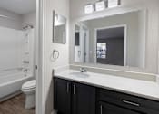 Thumbnail 10 of 29 - bathroom with a white sink and black cabinets at Manchester at Mansell, Roswell, GA 30076 