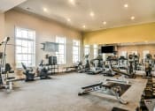 Thumbnail 19 of 29 - a spacious fitness room with cardio equipment and a flat screen tv at Meridian Park in Collierville, TN 38017