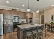 Thumbnail 1 of 29 - Kitchen with stainless steel appliances and bar at Meridian Park in Collierville, TN 38017
