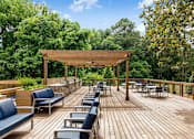 Thumbnail 18 of 27 - A wooden deck with blue chairs and a canopy. at Mill House at East Cobb, Marietta, GA
