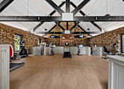 Thumbnail 22 of 27 - A gym with a wooden floor and a brick wall. at Mill House at East Cobb, Marietta, GA 30067 
