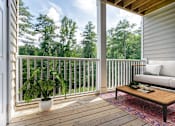 Thumbnail 20 of 30 - A wooden deck with a white sofa and a potted plant.