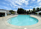 Thumbnail 22 of 30 - A large swimming pool with a white fence around it.