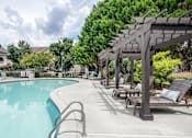 Thumbnail 23 of 30 - A pool with a metal ladder and a pergola with cushioned seating.
