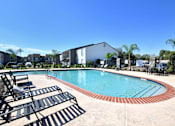 Thumbnail 13 of 24 - Pool surrounded by sun loungers at Normandy Woods in Riviera East, Houston, TX, 77015
