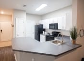 Thumbnail 2 of 25 - Kitchen with White Cabinetry and Black Appliancesat One Rocky Ridge Apartment, Georgia