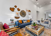 Thumbnail 10 of 25 - A living room with a blue couch and a coffee table.