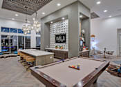 Thumbnail 9 of 25 - A pool table is in the middle of a room with a shiny wooden floor.
