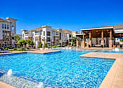 Thumbnail 19 of 25 - A large swimming pool with a fountain in the middle of it.