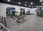Thumbnail 13 of 25 - A spacious gym with a variety of equipment including treadmills, elliptical machines, and weight machines.