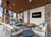 Thumbnail 18 of 25 - A patio with a couch, chairs, and a table with a sign that says "OVILLA".