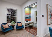 Thumbnail 21 of 25 - Two blue chairs with orange pillows in a room with a painting on the wall.