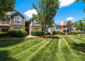Thumbnail 27 of 36 - Meticulously maintained grounds with mature trees surround the soft green paint and brick exterior apartment homes at Autumn Park Apartments, Charlotte, NC 28262